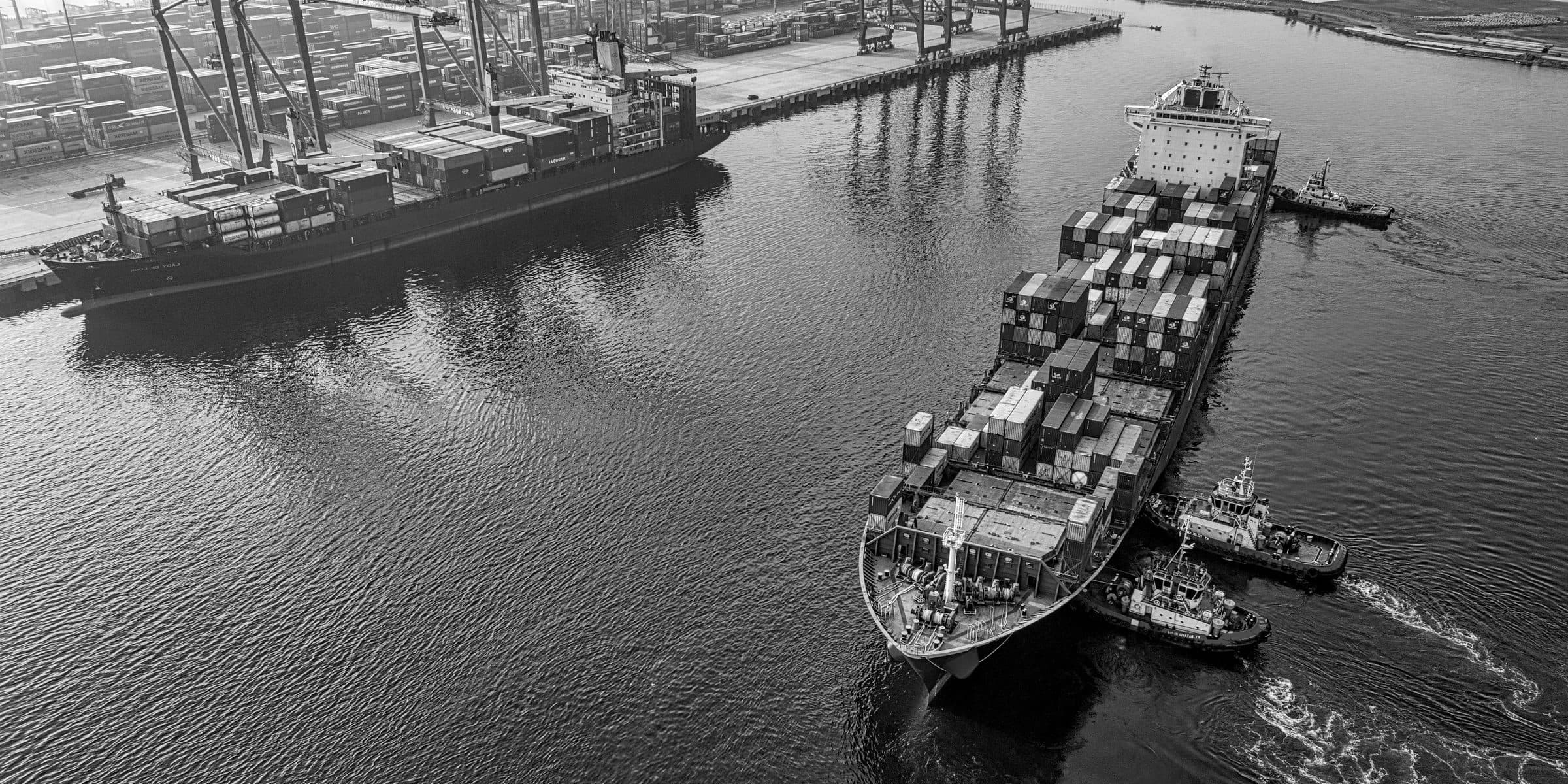 Aerial view of a major Asian container port with cargo being loaded onto a container ship